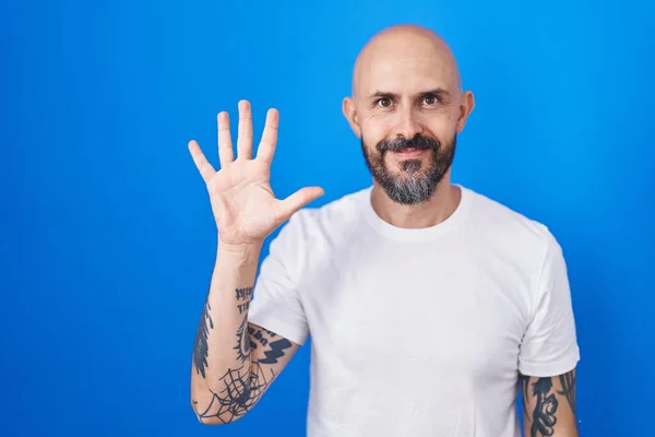 Ισπανόφωνος Άνδρας Τατουάζ Στέκεται Πάνω Από Μπλε Φόντο Δείχνει Και — Φωτογραφία Αρχείου