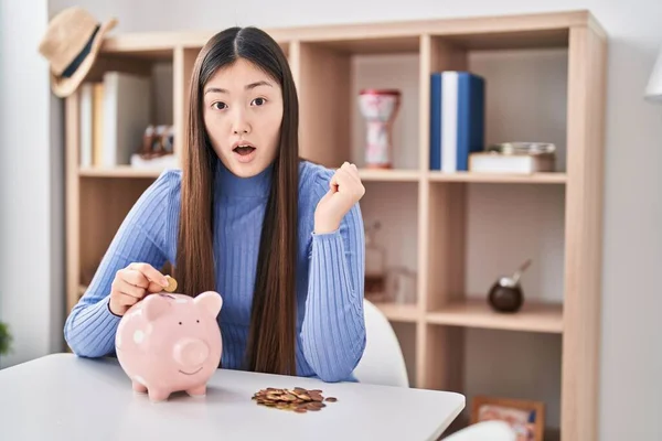 Kinesisk Ung Kvinna Sätta Mynt Spargris Bank Rädd Och Förvånad — Stockfoto