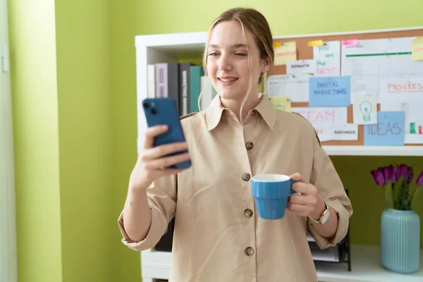 Young Caucasian Woman Business Worker Using Smartphone Drinking Coffee Office — Zdjęcie stockowe