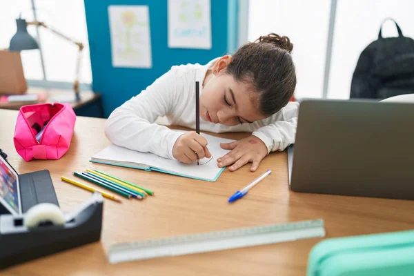 教室でノートパソコンを使ってノートに書く愛らしいパニック女子学生 — ストック写真