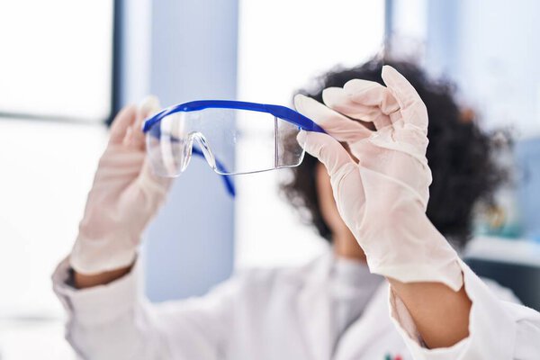 Young middle east woman scientist holding security glasses at laboratory