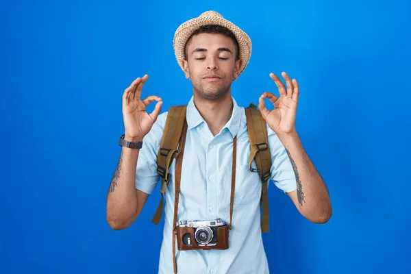ヴィンテージカメラを持っているブラジルの若者は 指で瞑想ジェスチャーを行う閉じて目でリラックスして笑顔 ヨガのコンセプト — ストック写真