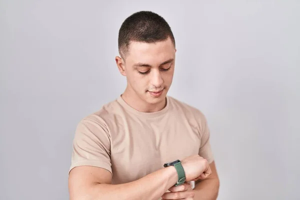 Young Man Standing Isolated Background Checking Time Wrist Watch Relaxed — Φωτογραφία Αρχείου