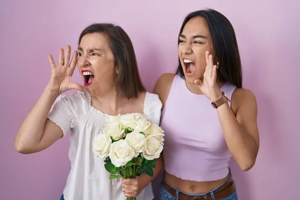 西班牙裔母亲和女儿手牵着一束白花 一边大喊一边大叫 传播概念 — 图库照片
