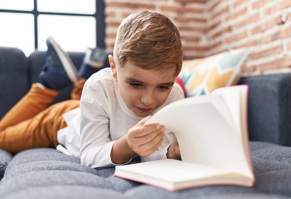 Liebenswerter Hispanischer Junge Liest Buch Hause Auf Sofa Liegend — Stockfoto