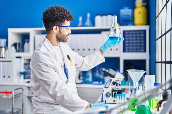 Hombre Árabe Joven Con Uniforme Científico Que Mide Líquido Laboratorio —  Fotos de Stock