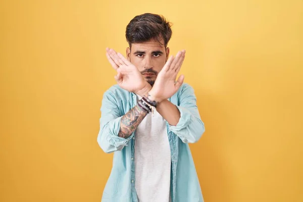 Young Hispanic Man Tattoos Standing Yellow Background Rejection Expression Crossing — ストック写真
