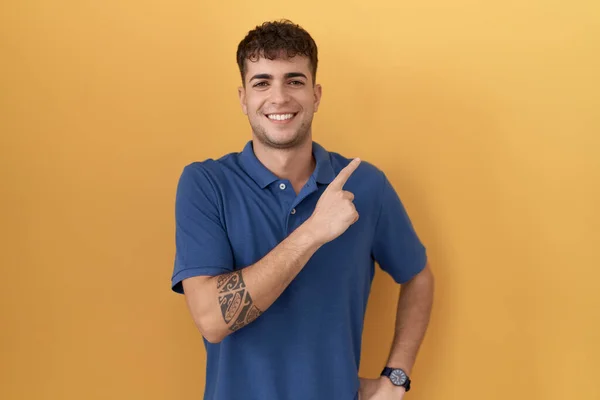 Young Hispanic Man Standing Yellow Background Cheerful Smile Face Pointing — Φωτογραφία Αρχείου