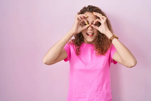 Young Caucasian Woman Standing Pink Background Doing Gesture Binoculars Sticking — Fotografia de Stock