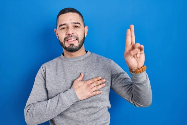 Латиноамериканец Стоящий Синем Фоне Улыбаясь Ругаясь Рукой Груди Пальцах Вверх — стоковое фото