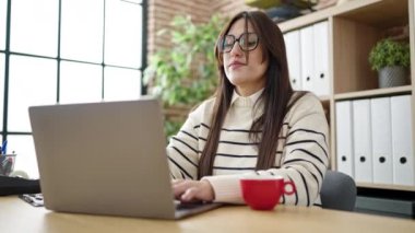 Genç, güzel İspanyol iş kadını. Laptop kullanıyor. Ofiste kahve içiyor.