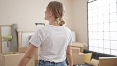 Young blonde woman smiling confident standing at new home