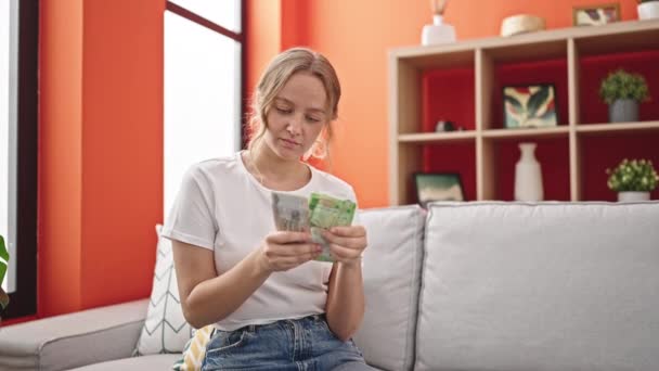 Jonge Blonde Vrouw Glimlachen Zelfverzekerd Tellen Rusland Roebels Bankbiljetten Thuis — Stockvideo