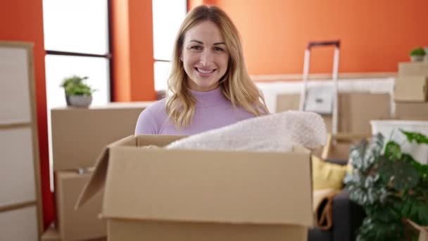 Young Beautiful Hispanic Woman Smiling Confident Holding Package New Home — Video