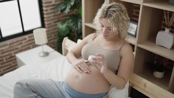 Jonge Zwangere Vrouw Aanbrengen Van Huidlotion Buik Slaapkamer — Stockvideo