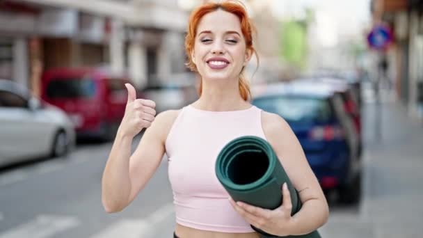 Elinde Yoga Minderiyle Gülümseyen Genç Kızıl Saçlı Kadın Sokakta Hareketi — Stok video