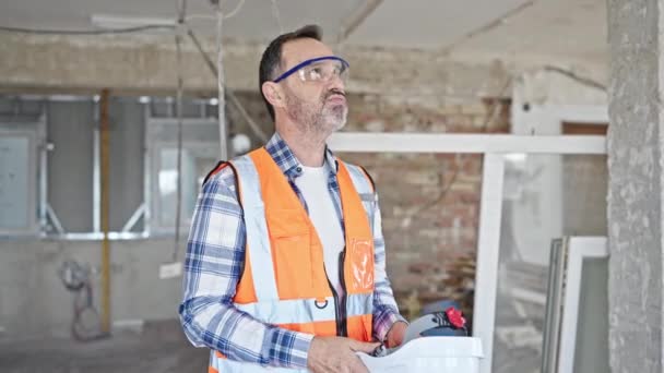 建設現場で手のファンとしてハードハットを使用して疲れている中年の男性ビルダー — ストック動画