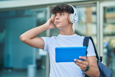 Genç İspanyol öğrenci üniversitede touchpad 'de video seyrediyor.