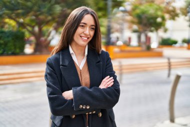 Sokakta kollarını kavuşturmuş genç, güzel İspanyol bir kadın.