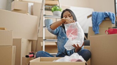 African american woman packing cardboard box at new home