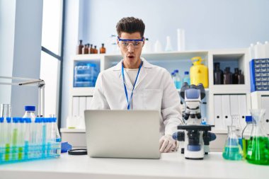 Laboratuvarda çalışan Latin asıllı genç bir adam video çekiyor. Korkmuş ve hayrete düşmüş. Şaşırmış ve ağzı açık. 