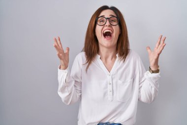 Esmer kadın, izole edilmiş beyaz arka planda durup başarının çılgınlığını kutlarken kollarını kaldırmış ve gözlerini kapatmış heyecanlı çığlıklar atıyordu. Kazanan konsept 