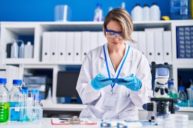 Young woman scientist make photo to pills at laboratory