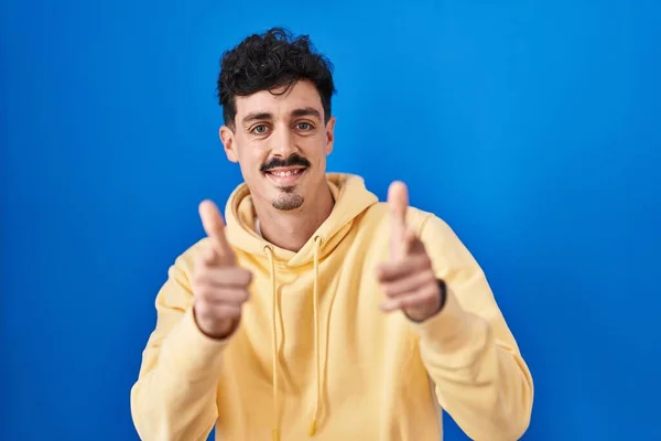 Hispanic Man Standing Blue Background Pointing Fingers Camera Happy Funny — Zdjęcie stockowe