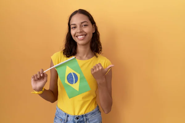 Young Hispanic Woman Holding Brazil Flag Pointing Back Hand Thumbs — Stock Photo, Image