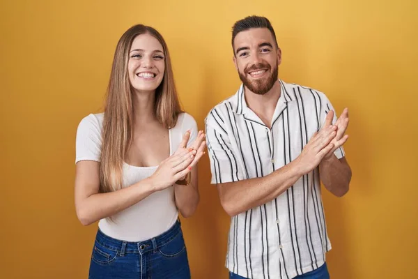 Junges Paar Das Vor Gelbem Hintergrund Steht Klatscht Und Applaudiert — Stockfoto