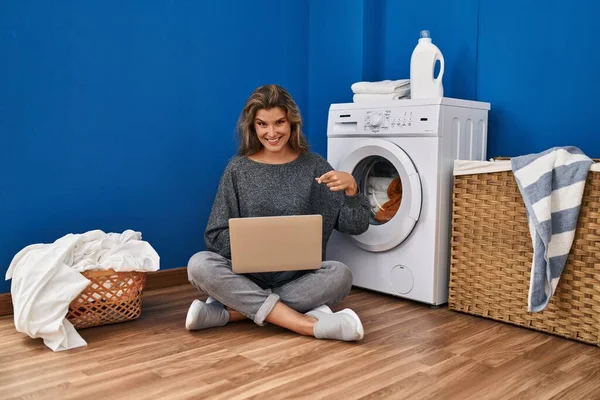 Çamaşır Bekleyen Genç Bir Kadın Dizüstü Bilgisayar Kullanarak Mutlu Bir — Stok fotoğraf