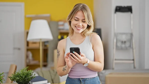 Mladá Blondýna Žena Pomocí Smartphone Stojící Novém Domově — Stock fotografie