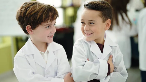 可愛いです少年たち笑顔自信を持って立ってとともに腕交差ジェスチャーで実験室教室 — ストック写真