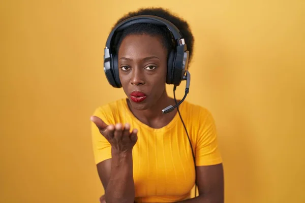 Afrykanka Kręconymi Włosami Stojąca Nad Żółtym Tłem Nosząca Słuchawki Patrzące — Zdjęcie stockowe