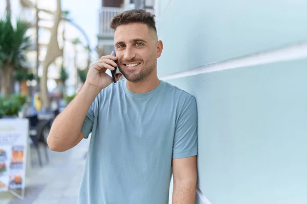 Joven Hombre Hispano Sonriendo Confiado Hablando Teléfono Inteligente Calle —  Fotos de Stock