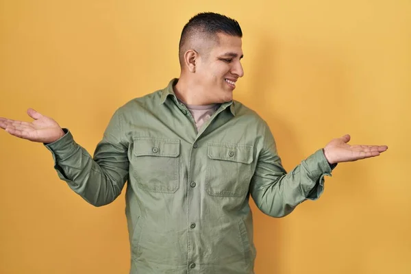 Hispánský Mladý Muž Stojící Nad Žlutým Pozadím Úsměvem Ukazující Rozevřené — Stock fotografie