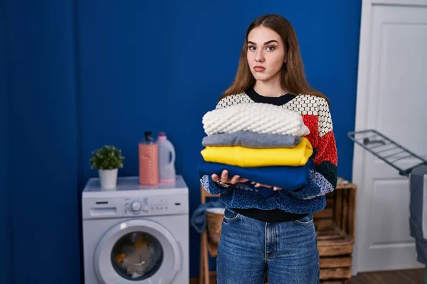 Young Hispanic Girl Holding Clean Laundry Skeptic Nervous Frowning Upset — Stock Photo, Image