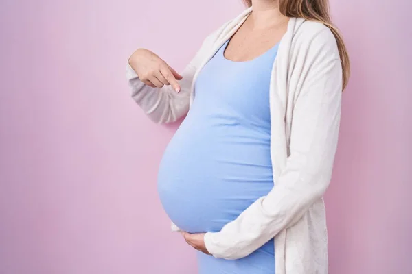 임신부 미소를 지으며 손가락으로 가리키면서 아기를 기다리고 — 스톡 사진