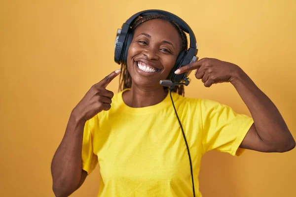 Mujer Afroamericana Escuchando Música Usando Auriculares Sonriendo Alegre Mostrando Señalando —  Fotos de Stock