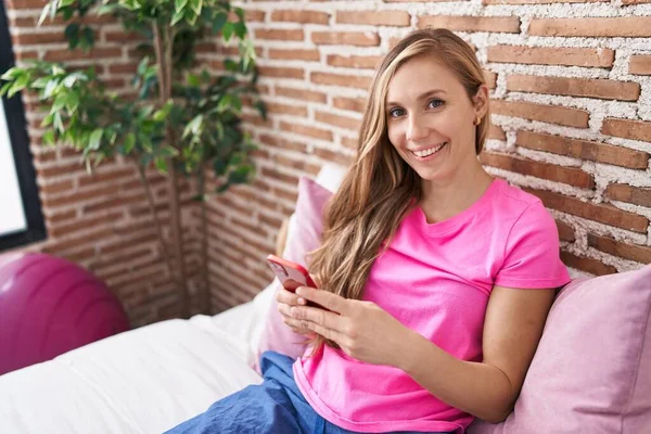 Jonge Blonde Vrouw Met Behulp Van Smartphone Zitten Bed Slaapkamer — Stockfoto