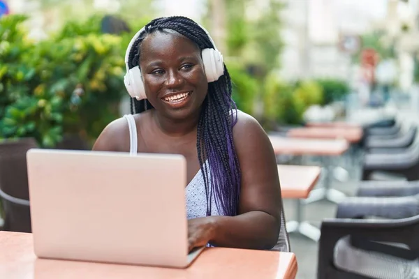Kahve Dükkanının Terasında Dizüstü Bilgisayar Kulaklık Kullanan Afrikalı Amerikalı Kadın — Stok fotoğraf