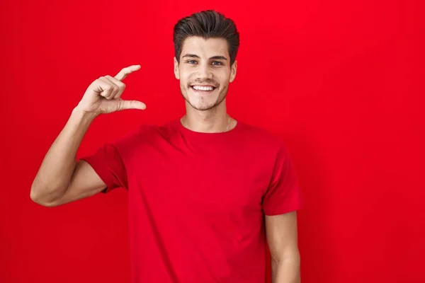 Joven Hombre Hispano Pie Sobre Fondo Rojo Sonriente Seguro Gesto — Foto de Stock