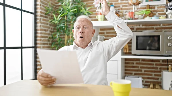 Oudere Grijsharige Man Leest Document Zittend Tafel Met Vrolijke Uitdrukking — Stockfoto