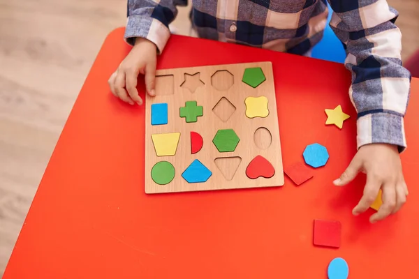 stock image Adorable caucasian boy playing with maths puzzle game sitting on table at kindergarten