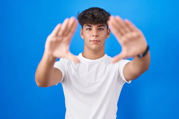 西班牙裔青少年站在蓝色的背景上 用手掌和手指 相机的视角拍摄画面 — 图库照片