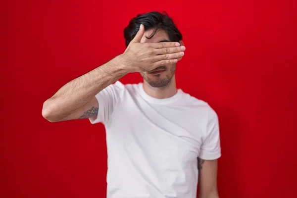 Young Hispanic Man Standing Red Background Covering Eyes Hand Looking — Photo