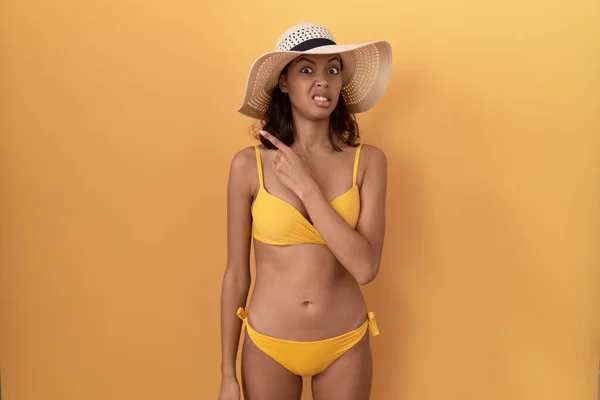 Young Hispanic Woman Wearing Bikini Summer Hat Pointing Aside Worried — Stock Photo, Image