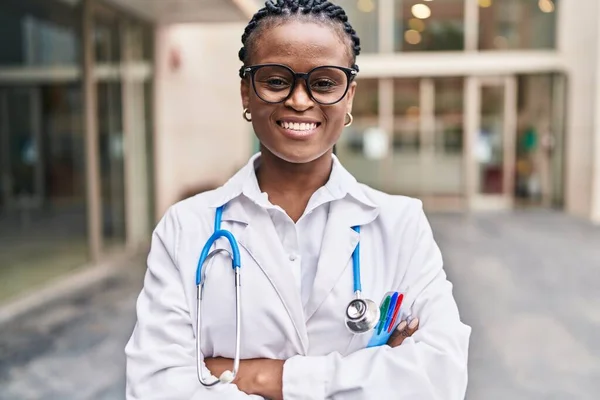 Mujer Afroamericana Doctora Sonriendo Confiada Pie Con Los Brazos Cruzados —  Fotos de Stock