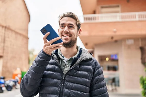 若い男は自信を持って路上でスマートフォンで話して笑っている — ストック写真