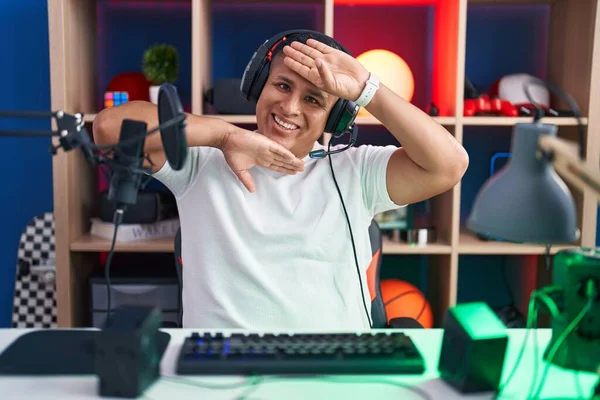 Молодой Латиноамериканец Играющий Видеоигры Веселый Улыбающийся Глядя Буу Поднятыми Руками — стоковое фото